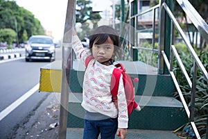 Little girl on subway waiting the bus looking camera