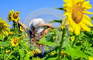 Little girl in sunflower field. yellow flower of sunflower. happy childhood. beautiful girl wear straw summer hat in