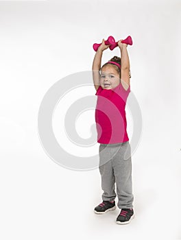 Little girl in sweat pants lifting weights