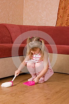 The little girl sweeps a floor