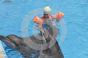 Little girl swim with dolphins