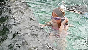 Little girl swim underwater in swimming pool. Slow Motion