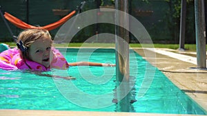 Little girl swimming in float in the pool