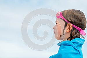 Little girl in swimming glasses wrapped in a towel - after swimming in the sea