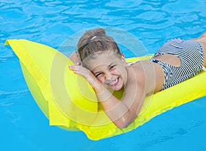 Little girl swimming on inflatable beach mattress