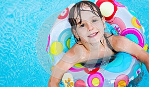 Little girl in swimming pool with float ring