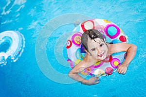 Little girl in swimming pool with float ring