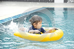 Little girl swimming in the pool in inflatable boat