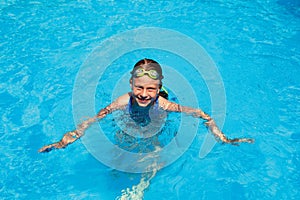 Little girl swims in swimming pool