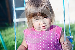 Little girl swing outdoor at summer, child playing