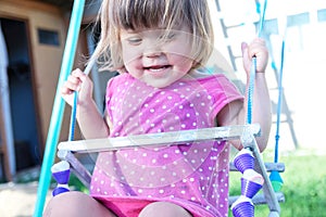 Little girl swing outdoor , toddler having fun on playground, children playing