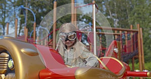 Little girl swing on rocking plane in children playground.