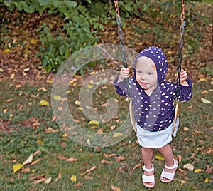 Little Girl Swinging on Fall Day