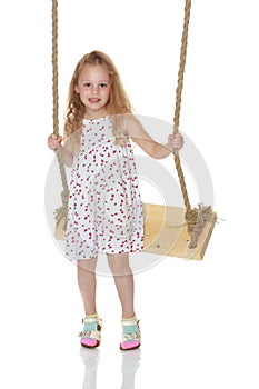 Little girl swinging on a swing. Isolated on white background