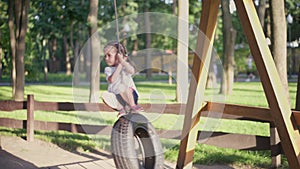 Little Girl Swinging Swing Tire Outdoor Public Park Day Summer Happy Childhood