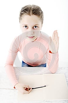 Little girl at the table in school on white