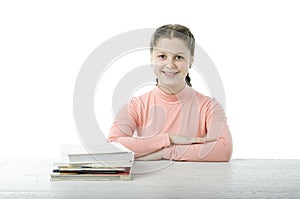 Little girl at the table in school on white