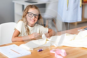 Little girl tailoring and looking at camera