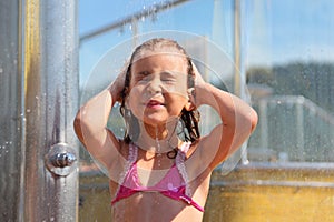 Little girl takes shower after swimming