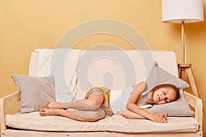 Little girl taking day nap, sleeping on cozy comfortable couch at home, cute adorable kid child with closed eyes lying resting on