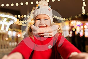 Little girl taking selfie at christmas market