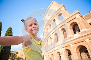 Little girl taking selfie in front of Colosseum in Rome, Italy.