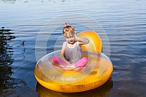 Little girl talking on a cell phone, sitting in an inflatable chair
