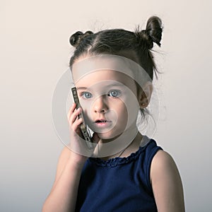 Little girl talking mobile phone. Child using a mobile phone