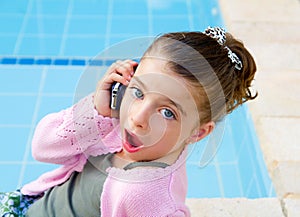 Little girl talking mobile phone with surprise