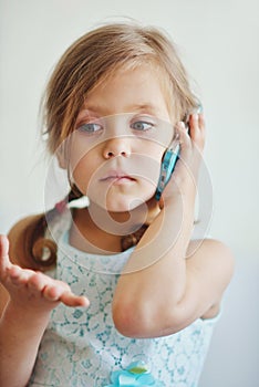 Little girl talking by phone