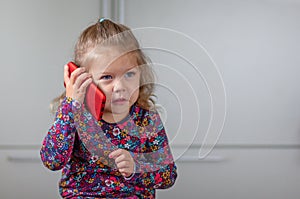 Little girl talking to mobile phone looking aside