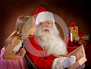 Little Girl Talking to Santa Clause While He Writes Magic Feathe
