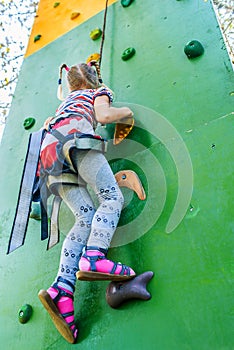 Little girl talking trains on climbing wall