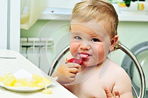 Little girl tasting strawberry