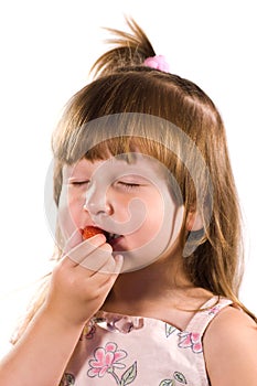 Little girl tasting strawberry