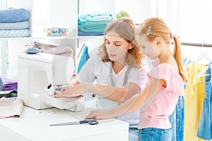 Little girl is taught to sew