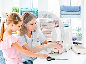 Little girl is taught to sew