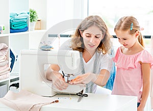 Little girl is taught to sew