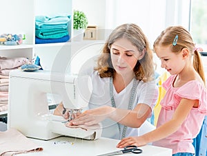 Little girl is taught to sew