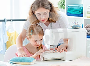 Little girl is taught to sew