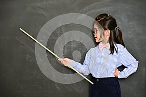 Little girl teacher teaching in black chalkboard photo