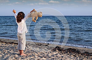 Little girl with teddy bear on beach