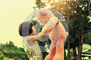 little girl with teddy bear standing and sunset