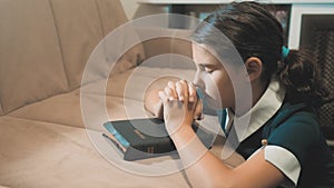 Little girl teenager praying in the night. Little girl hand praying. little girl holy bible prays with bible in her