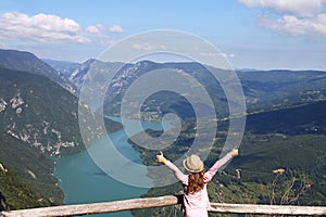 Little girl with thumbs up standing on mountain