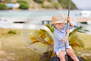 Little girl on tire swing