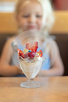 Little girl about to dig in to an ice cream sundae