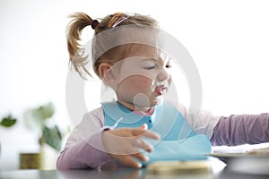 Little girl toddler picking her food, making faces