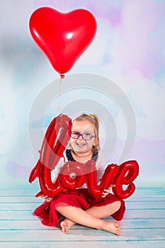 Little girl toddler with red heart balloonand love sign. Valentines day concept