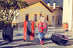 Little girl travel with suitcases, family tourism